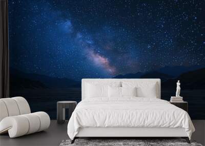  The sky glows with stars and the Milky Way shines brightly in the distance over a mountain range with a river flowing through it Wall mural