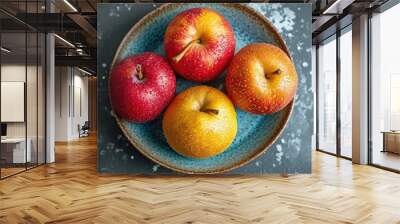  three apples and two oranges on a blue plate on a gray surface with sprinkles on the surface. Wall mural