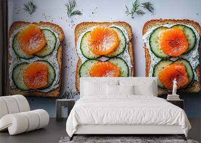   Three slices of bread with cucumber and orange on white surface with rosemary sprig Wall mural