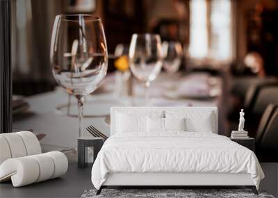 A close up shot of a restaurant table set up with tableware and wine glass. Concept of dining, hospitality and catering. Horizontal image with free space for text. Wall mural