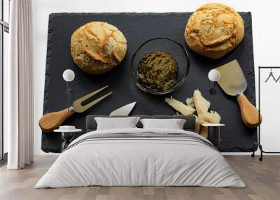 A dark cheese platter set with pesto sauce, Parmesan cheese, and two loaves of bread. Italian food. Flat lay. Traditional breakfast, snack or lunch. Isolated on white Wall mural