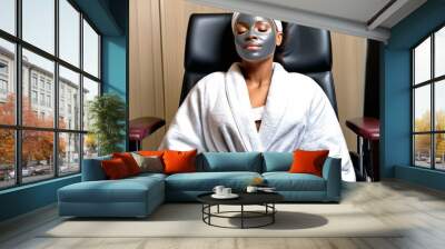 Attractive young African American woman in a beauty salon in a white terry robe with a cosmetic mask on her face. Facial skin care Wall mural