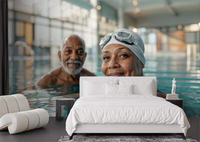 Senior black couple in swimming pool. Portrait of happy mature woman and man in sport activity. Active adult people swim in swimming pool. Water exercise and fun. Elderly swimmers. Aqua retired sport Wall mural