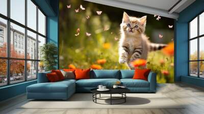 Cute playful kitten on green grass outdoors catching butterflies. Children's pet. Wall mural