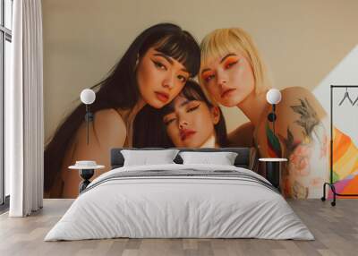 Four women with unique styles and alternative hair colors sitting closely together, showcasing modern beauty and fashion against a light background Wall mural