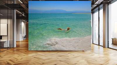 Girl relaxing in the water of Dead Sea Wall mural