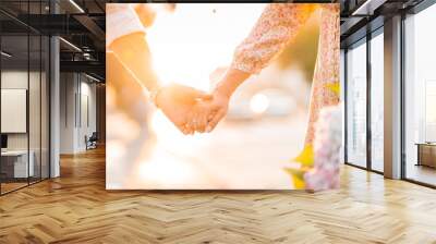 hands of a loving couple on a sunset background Wall mural