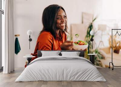 Beautiful young woman eating salad in the kitchen in the morning. Healthy food. Close up. Portrait shot Wall mural