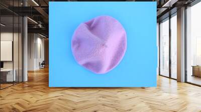 Lilac wool beret on a blue background. Wall mural