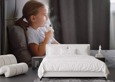 Little girl use inhaler nebulizer lying in bed in bedroom. Child asthma inhaler, nebulizer steam, flu or cold concept. Copyspace Wall mural