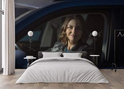 night portrait of a beautiful young woman driving a modern car. Wall mural