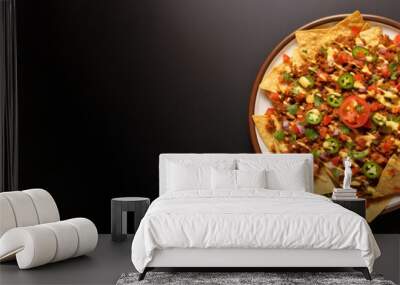 Plate of tasty spicy Mexican nachos isolated on black background Wall mural