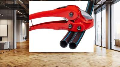 Plumber tools isolated. A red PVC pipe cutter for cutting plastic pipes and two pieces of PE pressure pipe or water pipe isolated on a white background. Space. Craftsman tools. Wall mural