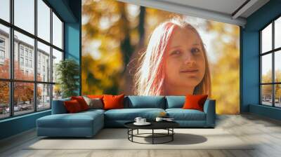 portrait of a cute blonde teenage girl in a pink jacket in the park Wall mural