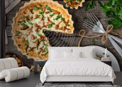 Homemade quiche or tart with chanterelles on an old wooden background. A slice of tart on a plate. Rustic style. Top view Wall mural