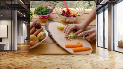 Russian vinaigrette preparation on wooden garden table with cook's hands. Vegetarian and vegan food concept     Wall mural