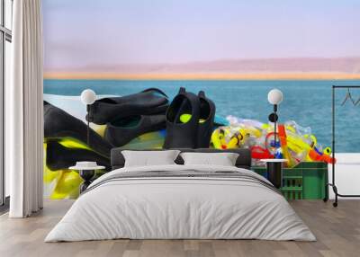 Snorkeling accessories. Fins, masks and tubes on the background of the sea Wall mural