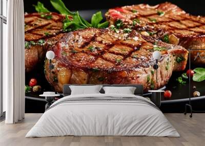 Tasty juicy grilled steaks on a black plate and on a black background. Ribeye steaks. Bone-in steaks. Wall mural