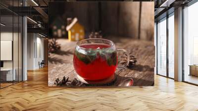 Tea with herbs, berries and fruits in a transparent cup on a wooden background Wall mural