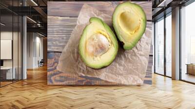 Two halves of avocado on wooden background Wall mural