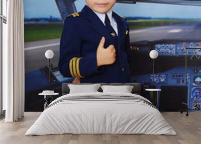 4 years old boy in a pilot suit posing inside the plane in the cockpit Wall mural