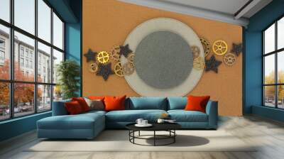 Two circles of different sizes on a brown background, metal gears and black shiny stars. Space for text... Wall mural