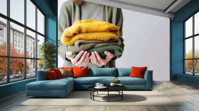 Woman's hand holding a stack of clothes. Clothes Donation, Renewable Concept.Preparing Garment at Home before Donate. Woman packs clothes for a donation or for moving. generative ai Wall mural