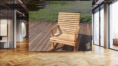 Wooden rocking chair on the river Bank, lake for people to relax. Wall mural