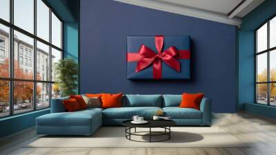 Blue gift box tied red ribbon on dark blue background. Wall mural