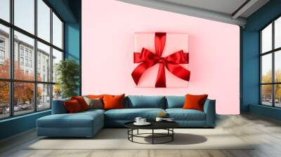 Pink gift box with red bow on the pink background. Valentine's day, 8 of March, Woman's day and birthday card. Wall mural