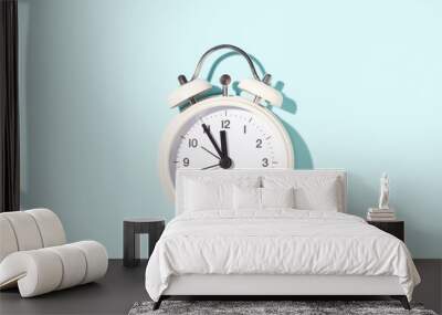 White alarm clock on blue background. Minimal styled, top view. Wall mural