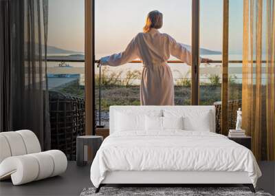 Beautiful woman from back in bathrobe on terrace of hotel room with Sea View Wall mural