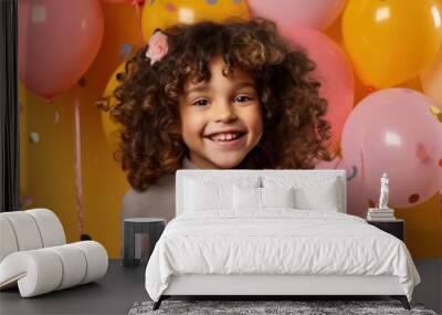 birthday girl smile complemented by vibrant inflatable balloons and confetti on orange backdrop Wall mural