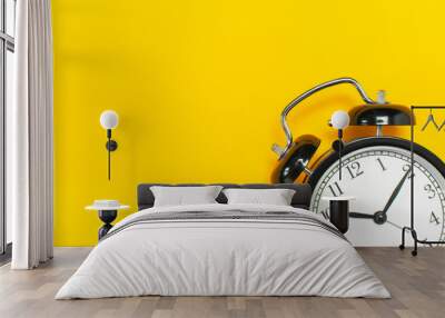 Black retro alarm clock on yellow background top view Flat lay copy space. Minimalistic background, concept of time, deadline, time to work, morning Wall mural