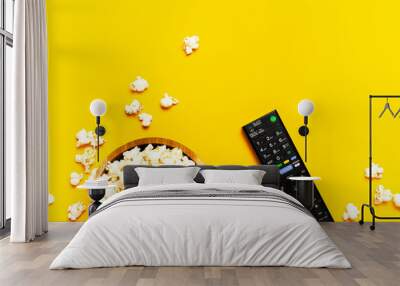 Black TV, audio remote control and popcorn on bright yellow background flat lay top view copy space. Minimalistic background with a remote control, watching a movie, series, set-top boxes, audio syste Wall mural