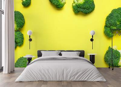 Creative food concept. Frame made of Fresh raw green broccoli on yellow background. Healthy vegetables, diet vegan organic food, vitamins. Flat lay top view copy space. Broccoli cabbage pattern Wall mural