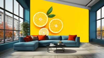 Ripe juicy lemons, orange and green leaves on bright yellow background. Lemon fruit, citrus minimal concept, vitamin C. Creative summer minimalistic background. Flat lay, top view, copy space. Wall mural