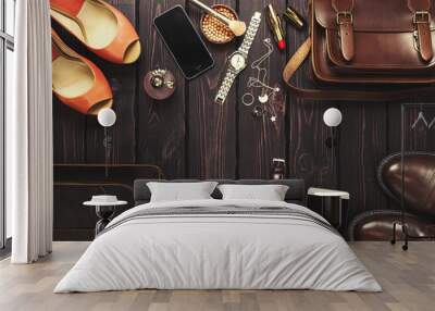 Top view, fashionable male and female personal items with space on a dark wooden background. Leather bag, shoes, watches, stylish accessories. Wall mural