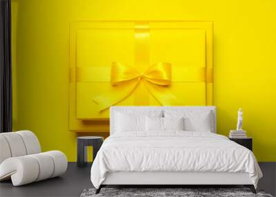 two bright yellow gift present box with ribbon and bow on yellow background top view copy space. fla Wall mural