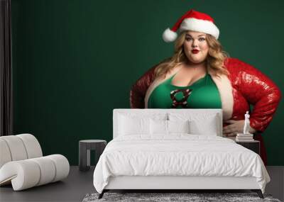 Plus size happy plump girl attractive overweight model on green background in red clothes in Christmas style, funny clown Santa Claus Wall mural