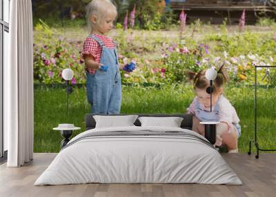 Two little girls sisters paint with finger paints Wall mural