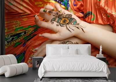 Two womans hands mehendi picture orange bright fabric with pleats Wall mural