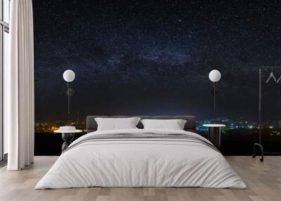 Panoramic view of the starry night sky above the city. Wall mural