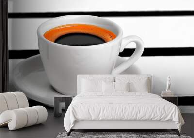 A white coffee cup with a black rim sits on a white saucer. The coffee is dark and has a strong aroma. Concept of warmth and comfort, as the coffee is a popular beverage for relaxation and socializing Wall mural