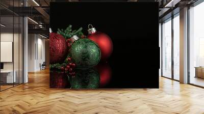 A black background with red and green Christmas decorations Wall mural