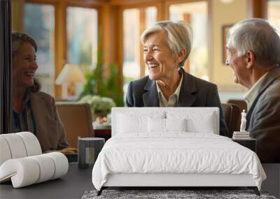 A group of older people sitting at a table laughing and having a conversation Wall mural