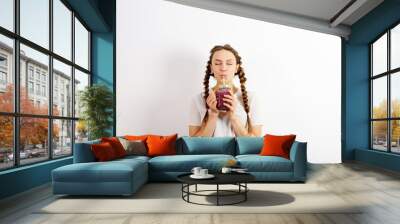 Enjoy a young woman with pigtails, drinking a delicious smoothie Wall mural