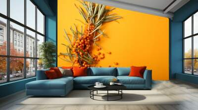 One branch of ripe sea buckthorn on yellow background Wall mural