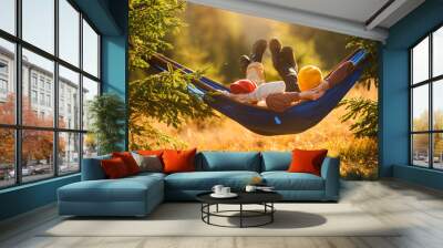 Children lie in a tourist hammock in the forest. Family holiday on tourist trip. Wall mural