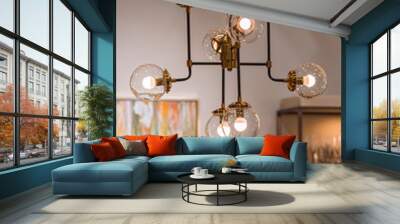 Modern brass chandelier. Pendant lamp with round glass shades and gold-colored copper tubes Wall mural